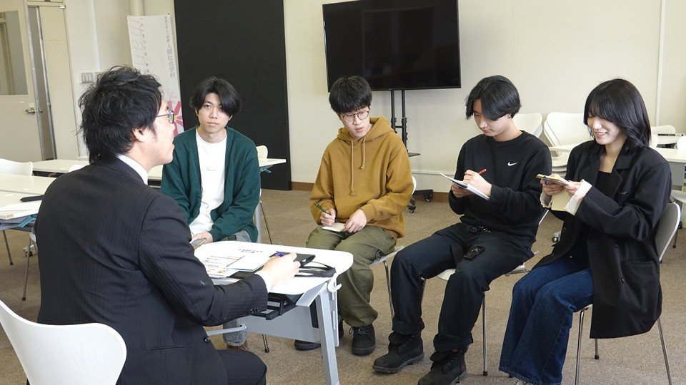 学生たちが男性職員にインタビューする様子